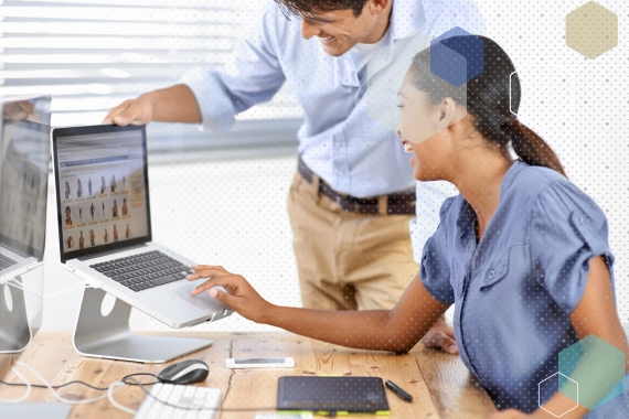 Two people working on website at a laptop.
